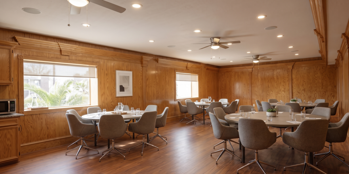 Community clubhouse room with tables and seating at Falls of Wilcrest